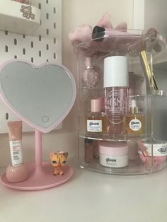 an assortment of beauty products displayed on a counter top in a bathroom area with pink accessories