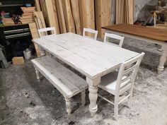 a white table and two chairs in a room with unfinished wood paneling on the walls