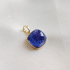 This stunning pendant is set in 14k Solid Yellow Gold with Natural Tanzanite with utmost precision. It is an unique gemstone pendant for nearly every occasion and is completely hassle-free jewelry. ITEM DETAILS: * GEM: Tanzanite * GEM Size: 12X12mm * GEM Shape: Square * Gem Weight: 14.06 carats * Gold Purity: 14KT * Gold Weight: 0.55 gram * Total Weight of the Pendant: 3.36 gram The Gold purity is guaranteed and it comes with authentic 14KT gold hallmark. Since my items are handmade, they are ab Luxury Tanzanite Gemstones For Gift, Luxury Tanzanite Gemstones As A Gift, Gold Tanzanite Pendant Jewelry, Gold Tanzanite Jewelry With Bezel Setting, Elegant Tanzanite Gemstones For Gift, Round High Luster Gemstones For Gifts, Luxury High Luster Gemstones For Gift, Yellow Gold Gemstones With Bezel Setting, Sapphire Tanzanite Gemstones As Gift