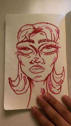 a drawing of a woman's face is shown in red ink on white paper