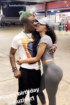 a man and woman standing next to each other in front of an airport parking lot