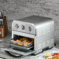 a toaster oven sitting on top of a counter with food in front of it