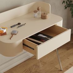 a white desk with an open drawer on it's side next to a potted plant