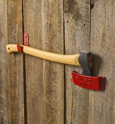 a hammer stuck in the side of a wooden door with a red handle on it