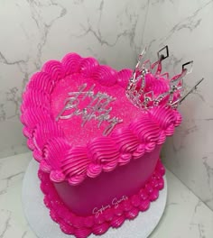 a pink heart shaped birthday cake with music notes on it and a tiara in the shape of a heart