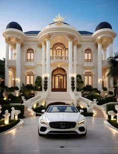 a white car parked in front of a large mansion