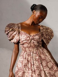 This dress is a testament to our artisans in Nigeria who have meticulously handcrafted fabric sourced from Lagos markets into a garment that transcends fashion and becomes an expression of individuality and a force for good. Exaggerated geometric sleeves Side seam pockets Smocked back bodice Midi Length 100% cotton Wash on cold Hang dry or tumble dry low Pattern placement might vary from pictured. Puff Sleeve Dress With Gathered Neckline For Gatherings, Ruched Puff Sleeve Dresses For Gatherings, Fitted Smock Dress With Puff Sleeves, Square Neck Dress With Smocked Bodice For Gatherings, Square Neck Dress With Fitted Bodice For Gatherings, Fitted Smock Midi Dress, Square Neck Ruched Dresses For Gatherings, Brown Dress With Smocked Bodice And Short Sleeves, Brown Short Sleeve Dress With Smocked Bodice