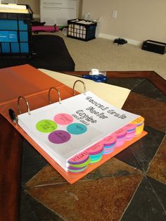 a binder that is sitting on top of a table in an office with several folders