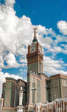 a large building with a clock on it's side and clouds in the background