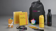 an assortment of personal items including a backpack, notebooks, pens and other office supplies