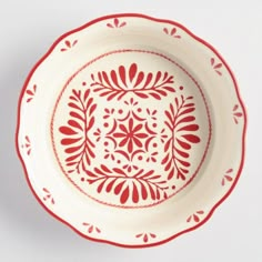 a red and white bowl with designs on it