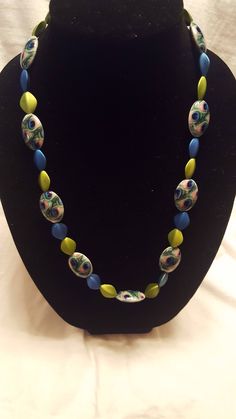 a necklace with multicolored beads on a black mannequin