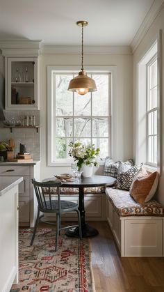 a kitchen with a window seat, table and bench in the middle of the room