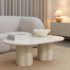 a white table sitting on top of a carpeted floor next to a couch in a living room