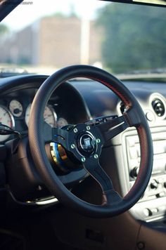 the interior of a car with steering wheel and gauges