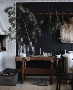 a room with black walls and wooden floors has plants in vases on the table