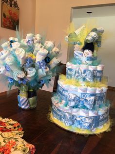 two stacks of diapers sitting on top of a table next to a vase filled with flowers