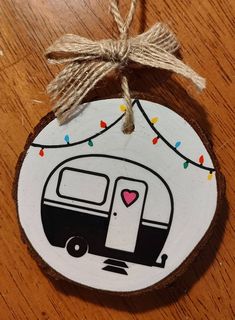 a wooden ornament with a camper painted on it