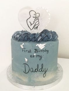 a blue cake with frosting and a heart on top that says first birthday as my daddy