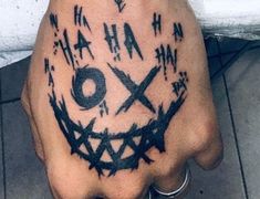 a person with a tattoo on their hand that has scissors and letters all over it