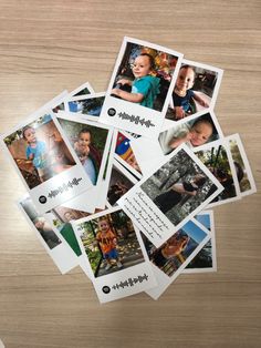 a pile of polaroid pictures sitting on top of a wooden table