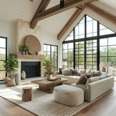 a living room filled with lots of furniture next to large windows on top of a wooden floor