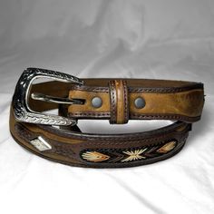 Embroidered Studded Western Leather Belt Layered Two-Tone Brown/Tan Leather Belt With Embroidered Yellow/Orange/Brown/Black Ombre Starbursts & Silver Tone Western Diamond Shaped Studs Size: Labeled 28; Estimated Modern S; For Best Fit, Always Mind All The Measurements Brand: 3-D Belts / Ddd Belts Good Condition; Overall Good Condition, But Has A Distressed Look To It; For Example, The Silver Tone On The Buckle And Studs Is Worn Off In Some Places, And The Leather Looks Greatjust Not Brand New (It’s Comfortably Broken In, Which Is Great) Measurements: Length, End To End: 34.5" Furthest Notch To Middle Of Buckle (Maximum Usable Length): 30.25" Nearest Notch T Sheepskin Coat Mens, Western Leather Belt, Tan Leather Belt, Black Ombre, Sheepskin Coat, Western Belts, Western Leather, Brown Belt, Belt Accessories