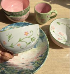 a person is holding a tea cup and saucer