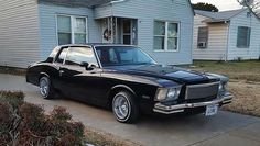 a black car parked in front of a house