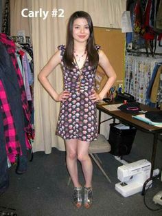 a young woman standing in front of a clothes rack