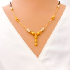 This exquisite 22k gold Mangal Sutra, weighing 11.8 grams, showcases an opulent two-tone design, blending the richness of yellow and white gold. The classic black beads add contrast to the 18-inch necklace, which features a 1-inch drop for added elegance. Secured with a hook lock, this piece offers both comfort and style. Ideal for those who appreciate luxurious craftsmanship, the two-tone finish gives this Mangal Sutra a modern twist while retaining its traditional essence. Perfect for making a statement on special occasions or as a standout daily piece. PRODUCT DETAILS Gold Purity(karat): 22k Item Weight(grams): 11.8 Item Finish: Yellow + White Gold Stone: Black Bead Necklace Length: 18" Drop Length: 1" Lock Style: Hook Lock Festive Black Necklace In 22k Gold, Traditional Gold Necklace With Black Beads, 22k Gold Dual-tone Necklace Gift, Festive Gold Necklace With Black Beads, Dual-tone 22k Gold Necklace For Gifts, Festive Gold Necklaces With Black Beads, Gold Temple Jewelry With Black Beads, Gold Pearl Necklace With Black Round Beads, Dual-tone Yellow Gold Necklace For Festivals