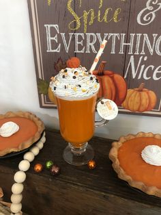 there is a pumpkin pie with whipped cream on top and two pies next to it