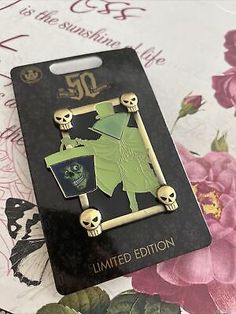 a pair of skull pins sitting on top of a card