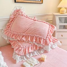 there is a pink bed with ruffled pillows on it