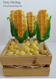 corn on the cob are sitting in a wooden box