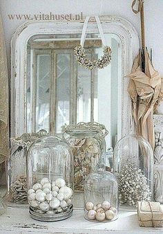 there are many glass jars on the mantle with eggs in them and other decorations around it