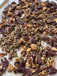 nuts and seeds on a baking sheet ready to be baked in the oven for christmas