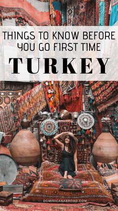 a woman sitting on top of a bed surrounded by rugs and vases with the words, things to know before you go first time turkey