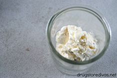 a glass bowl filled with whipped cream sitting on top of a white tablecloth covered floor