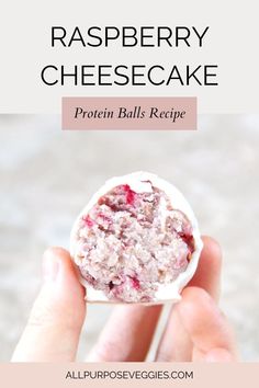 a hand holding up a raspberry cheesecake with the words, protein balls recipe