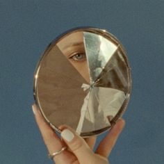 a person holding up a mirror to their face