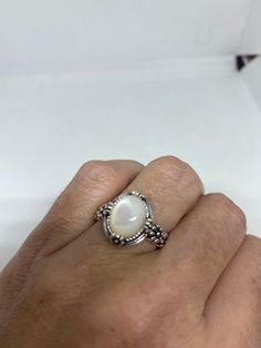 Lovely polished 925 sterling silver with a huge white Mother Of Pearl set in very detailed vintage filigree Size 7 or 9 We can size these with an additional $10- $20 fee for the jeweler All rings are shipped in a nice gift box. Check out our over a THOUSAND great reviews Engraving is $4 per letter and is not always perfect depending on the piece. It can take a few days if the jeweler is busy. This is payable to Paypal Judithsltd@gmail.com White Cabochon Moonstone Ring In Fine Jewelry Style, Fine Jewelry White Cabochon Moonstone Ring, White Cabochon Moonstone Ring Fine Jewelry, Classic White Filigree Ring With Intricate Design, Elegant White Filigree Ring With Intricate Design, Classic White Oval Moonstone Ring, Elegant White Moonstone Round Ring, Elegant White Round Moonstone Ring, Elegant White Moonstone Ring