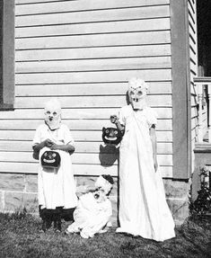 two children dressed up in halloween costumes standing next to each other with masks on their faces