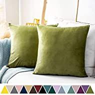 two green pillows sitting on top of a bed