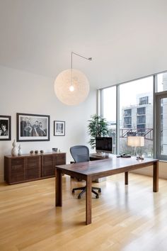 an office with large windows and wooden floors