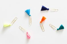 colorful paper clips with tassels on them sitting next to each other in different colors