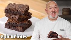 a man holding a plate with brownies on it