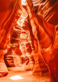 a narrow slot in the side of a canyon with light coming from it's windows