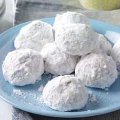 a blue plate topped with snowballs covered in powdered sugar