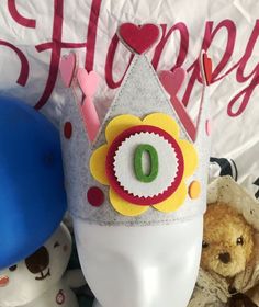 there is a crown on top of a head next to stuffed animals and a happy birthday sign